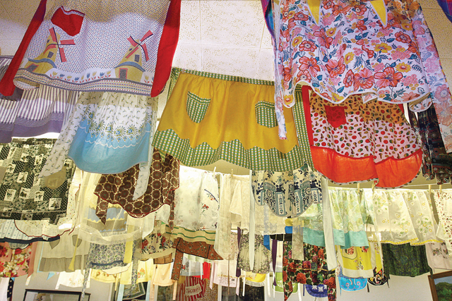 BARBARAELLEN KOCH PHOTO | Aprons on display lasy month from the private collection of Diane Schwindt. This event inspired the Apron Strings Project.
