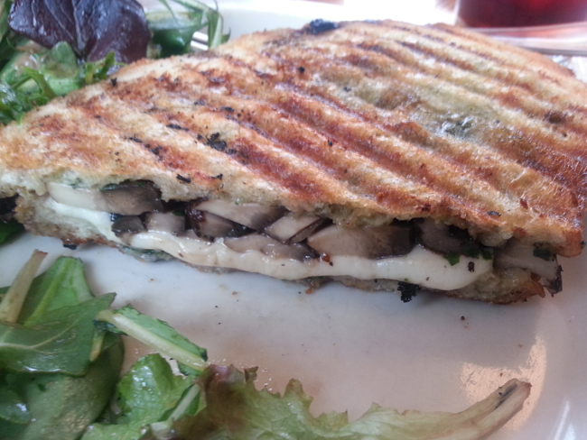 Sliced grilled portobello mushrooms with mozzarella cheese and house-made basil pesto on sourdough bread. Yum!