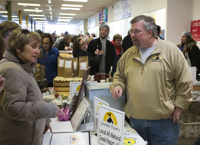 Hal Goodale from Goodale Farms discusses yogurt with Barbara Kummer of Riverhead at the indoor Riverhead Farmers Market. (Credit: Katharine Schroeder)