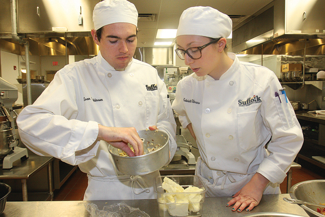 Evan Robinson (left) and Gabrielle Vitrano of East Islip prepare a pan with butter and sliced almonds for a kugelhoph dough. (Credit: Barbaraellen Koch)