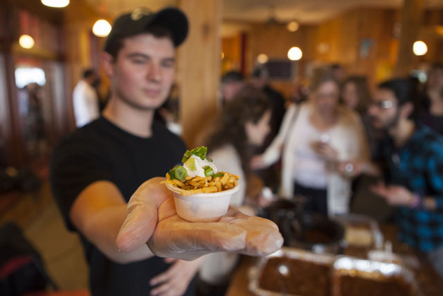 Dylan Brown of Erik's in Southold holds up a sample cup of chili.