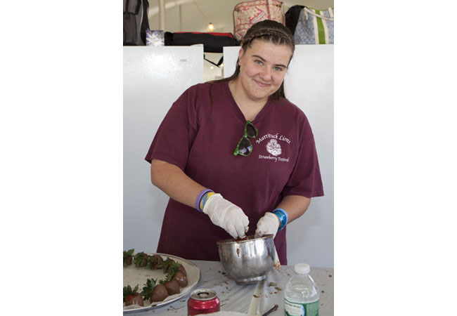 Volunteer Corinne Araneo dips strawberries into chocolate. (Credit: Katharine Schroeder)