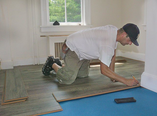 Michael Marrone of Rosanti Floors of Westhampton installs Quick Stop heather oak laminate floors in the laundry room which is designed by Marsha Fox-Martin Interiors of Quogue. (Credit: Barbaraellen Koch)