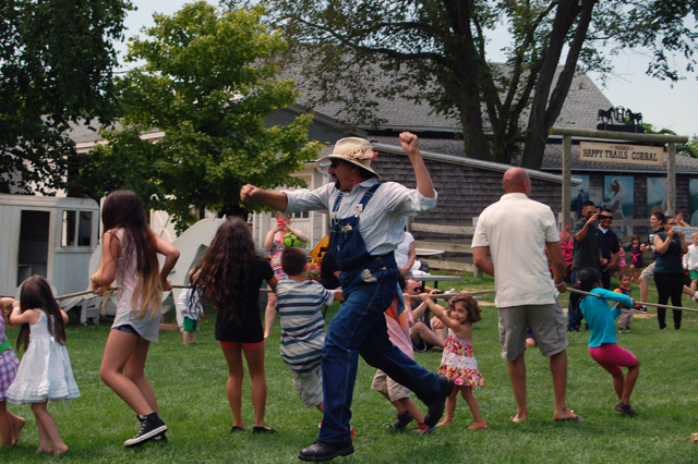 Harbes Family Farm mascot Farmer Fred leads a gam of tug-of-war at the Mattituck farm.