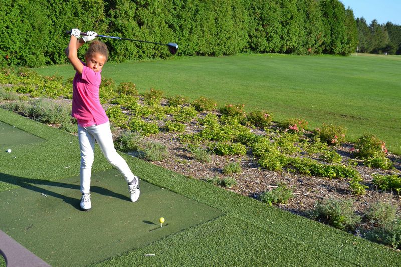 Young golfer swings a club at Great Rock Golf Course.