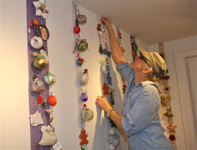 East End Arts gallery director Jane Kirkwood hanging ornaments in the "Holiday Gift Boutique" this week.