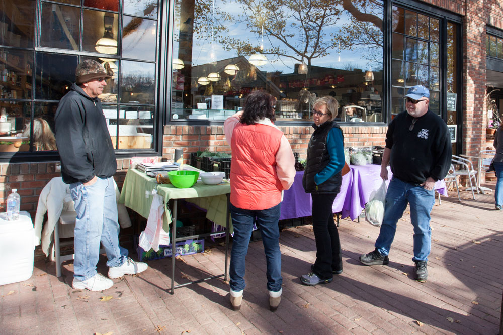 Gene Krupski, left, of MarGene Farms looks on as customers discuss what to buy.
