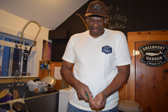 Douglas Latney of Greenport shucks some oysters.
