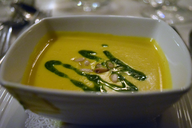 Curried winter squash soup with toasted pine nuts and chive oil.