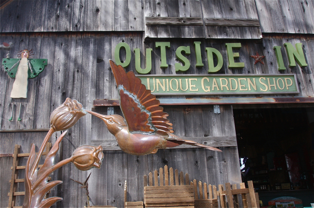 Two story barn garden shop with humming bird garden sculpture.