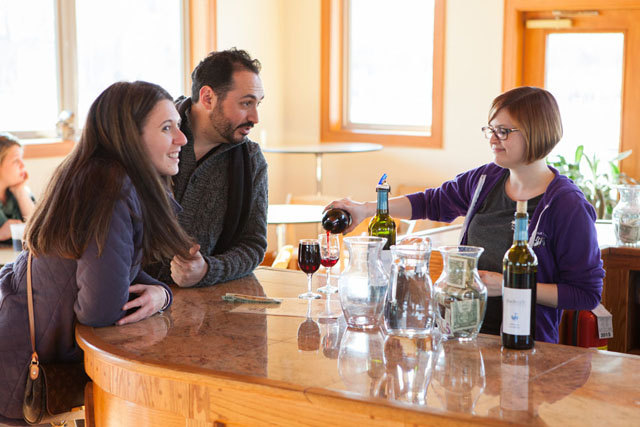 Kristen Gratten, right, pours wine for Jeanette Velsmid of Wantaugh and Brian Fort of Northport. 