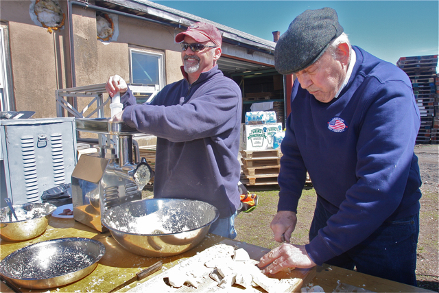 Doug Adams grinding the root as Bobby Bugdin (left) cuts it up.