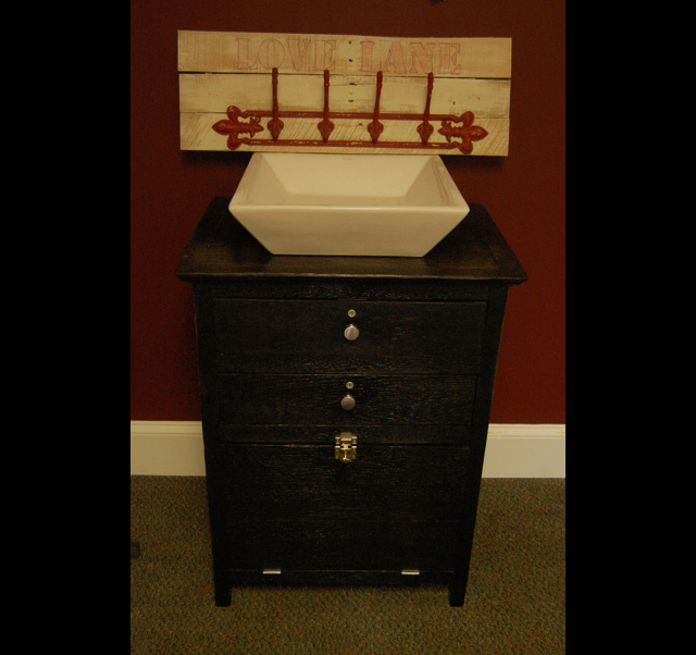 A barbershop cabinet that has been repurposed into a vanity.