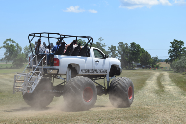Festival goers taking a ride on a monster truck.