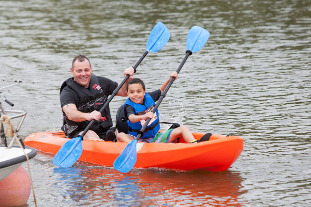 Casey Sheridan, age 10, and dad Albert cross the finish line after kayaking 2.5 miles.