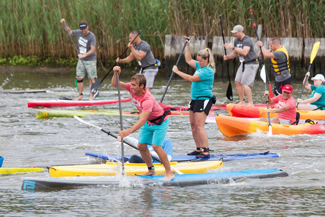 Stand up paddlers begin a race.