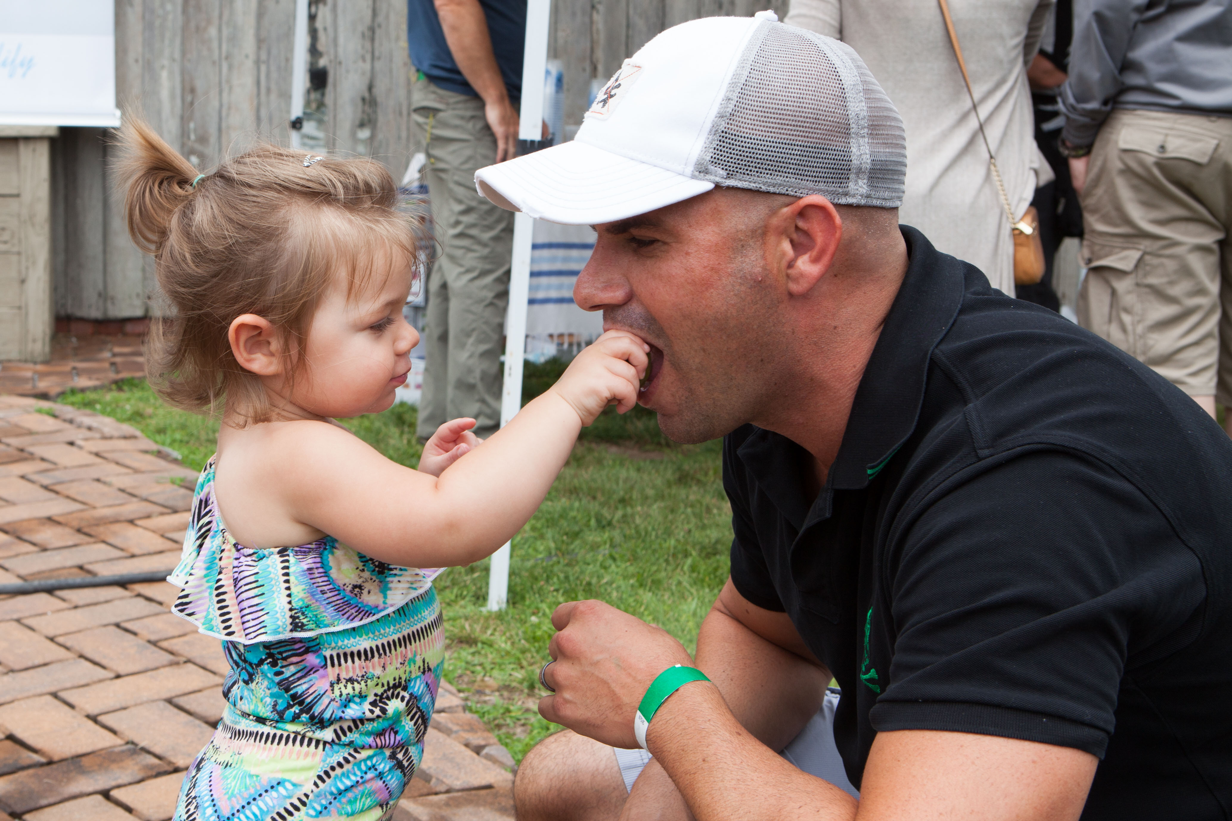 Ella Zwang, 22 months, offers a bite of her pickle to Steven Casey.