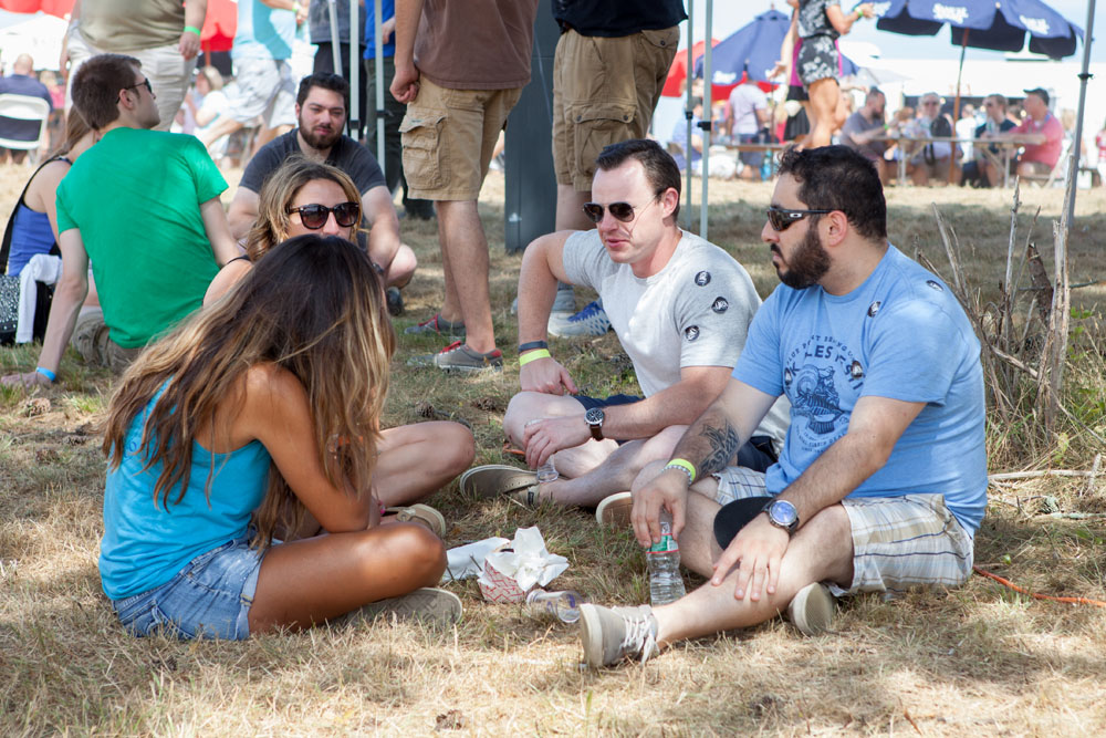 A group of friends enjoy a beer in the shade.