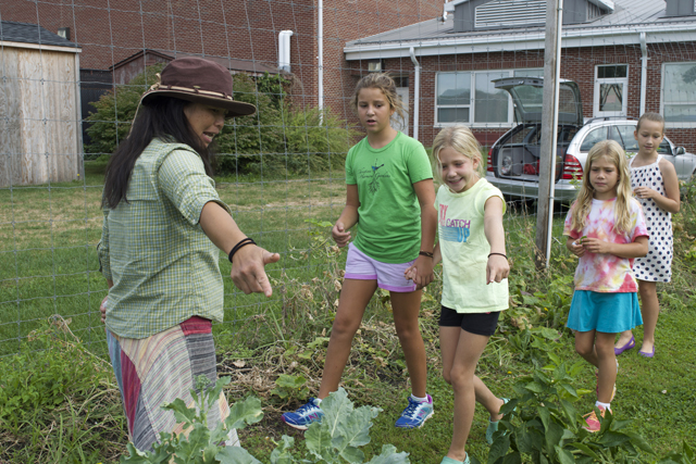 Southold Elementary School garden volunteer Sonomi Obinata gives students (from left) Amelia Harmon, 9, Grace Zehil, 8, Olivia Zehil, 7, and Emma DeTour, 11, a refresher in what's growing in the garden.
