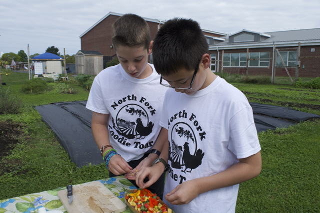 Mathew Garms and Miles Eisenberg, both 11 and of Southold, prepare a salad for North Fork Foodie Tour visitors.