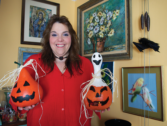Regina Rouge of the Riverhead Garden Club holds up two dried gourds that were painted to look like jack-o-lanterns. (Credit: Vera Chinese)