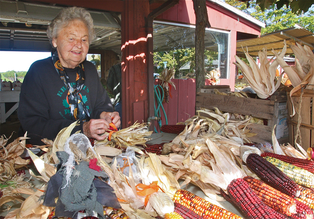 Helen Krupski works on her Indian corn bundles at the back of her family's farm stand.