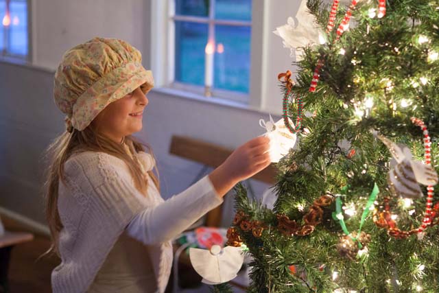 Savanna Smith, 9, of Southold decorates a tree during the Southold Historical Society's 2014 Candlelight Tour. (Credit: Katharine Schroeder, file photo)