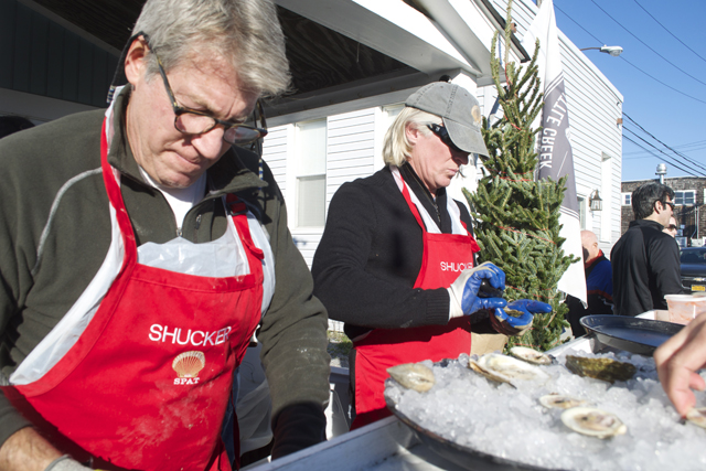 Spat volunteers Steve Schnee and Brian Parker shuck some shellfish.