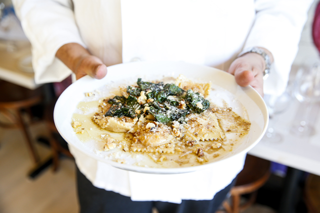 Cheewing holds a plate of butternut squash ravioli. (Credit: Randee Daddona)