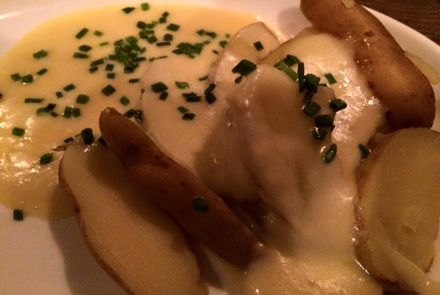 French raclette cheese melted over fingerling potatoes (Credit: Monique Singh-Roy)
