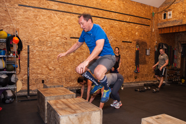 CrossFit member Bill Moore performs a box jump.