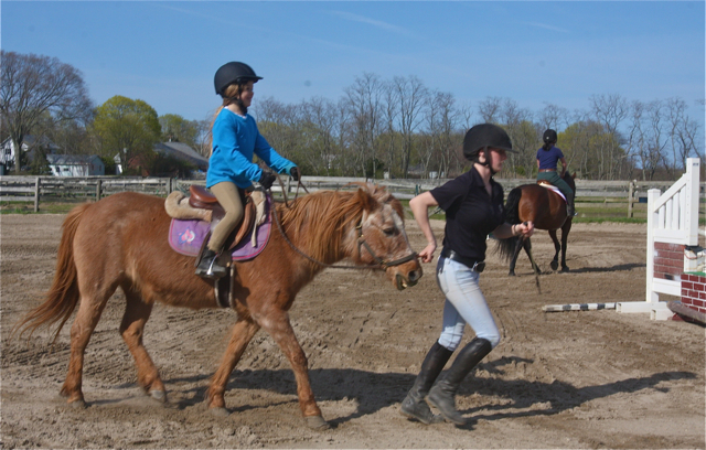 Elle O'Neill, 7, of Peconic, rides Pebbles the pony led by staffer Jacey Lengyel of Cutchogue