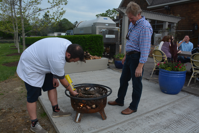 Chef Jeffrey Cochrane lights one of the fires as Manager Ron Goerler Jr. oversees.