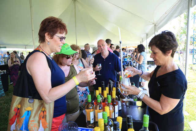Nina Dobris (left) of Queens and friend Susan Sugarman of Brooklyn taste wine poured by Rosemarie Pogoloff of Martha Clara Vineyards. (Credit: Krysten Massa) 