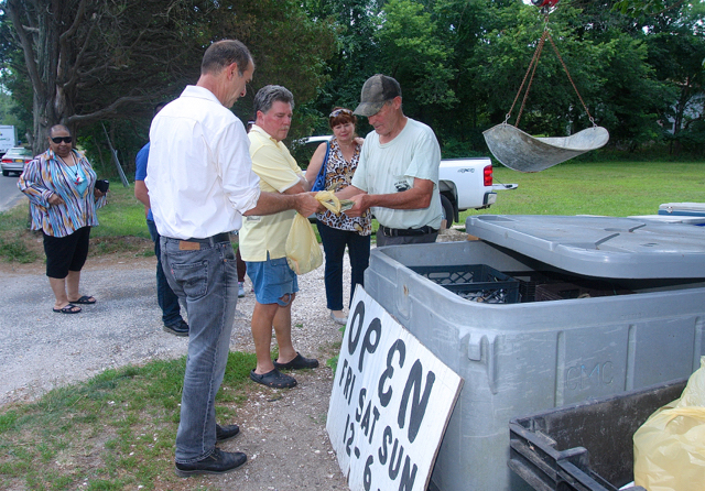 Bob tallying up with his customers. (Credit: Barbaraellen Koch)