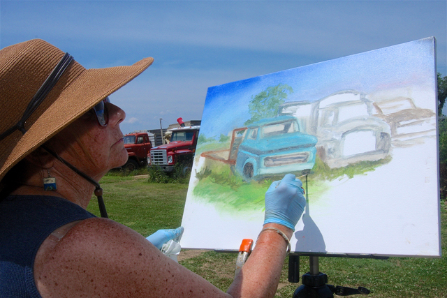 Janine Harrigan works on her old trucks painting Monday. (Credit: Barbaraellen Koch)