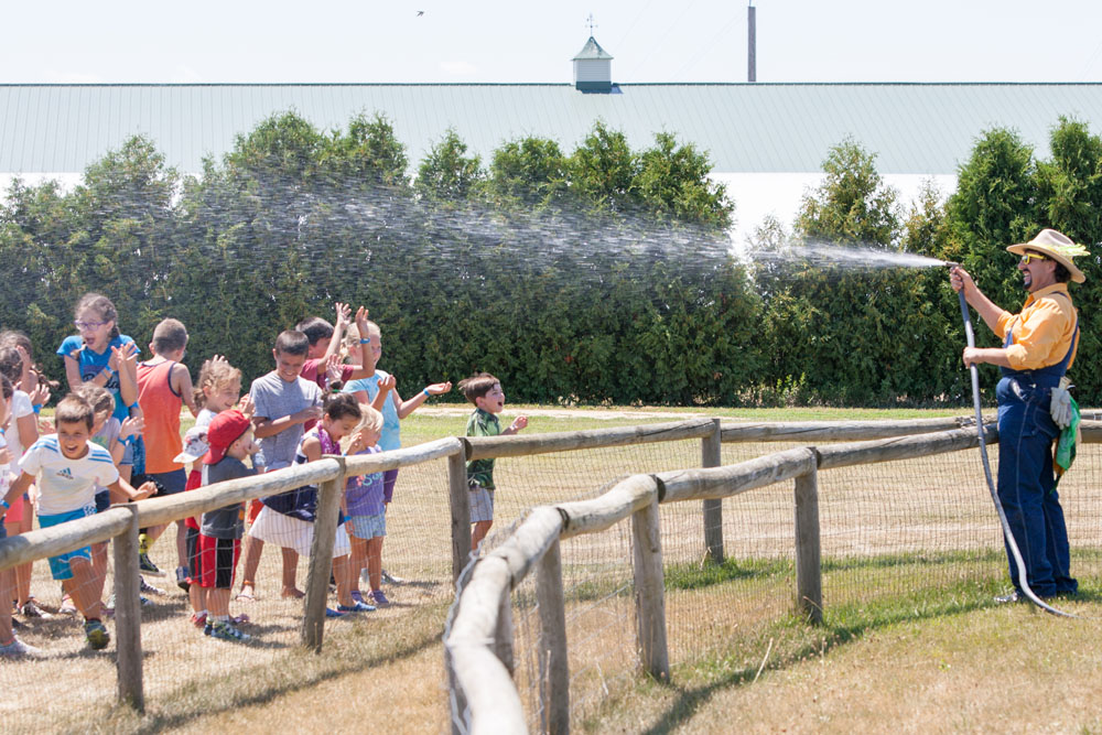 Farmer Fred cools down the kids as they wait for the pig race to start. (Credit: Katharine Schroeder)