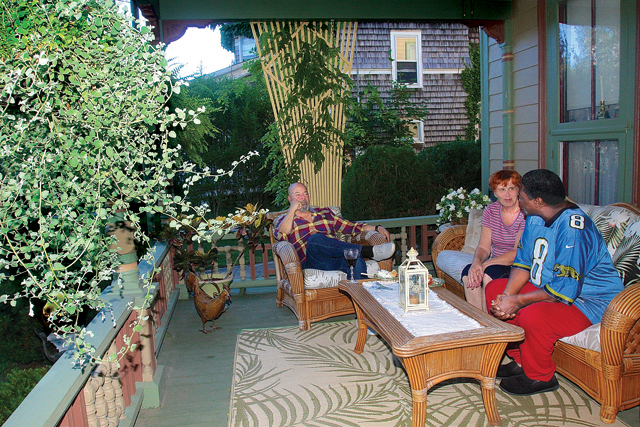 Bill and Theresa Zucconi talk with neighbor Miller Gilbert on the porch of their 1868 historic home on Lincoln Street in Polish Town. (Credit: Barbaraellen Koch)