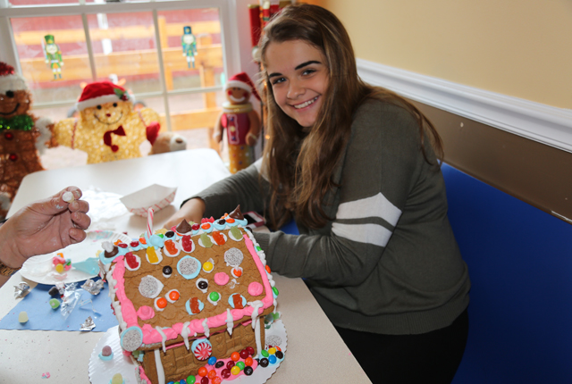 14-year old Faitra Pittarese of Middle island shows off her gingerbread house.