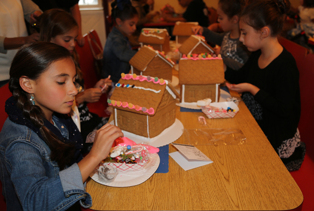 10-year old Amelia Vricella of Wading River decorates her gingerbread house.