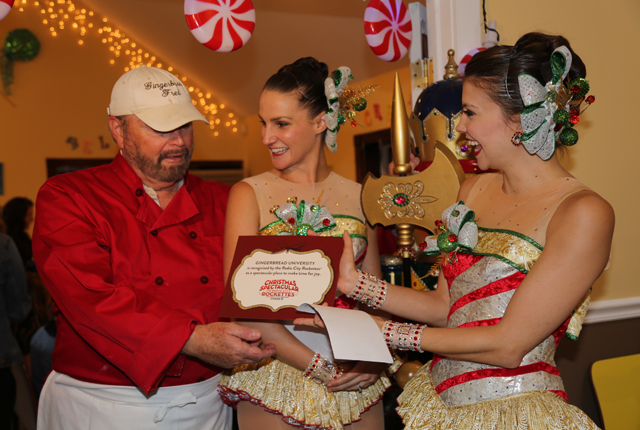 The Rockettes present owner Fred Terry Sr. with a certificate of excellence for Gingerbread University's contribution to the community.