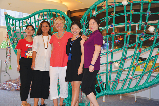 Roe, center, poses with project particpants in front of the scupture's fin.