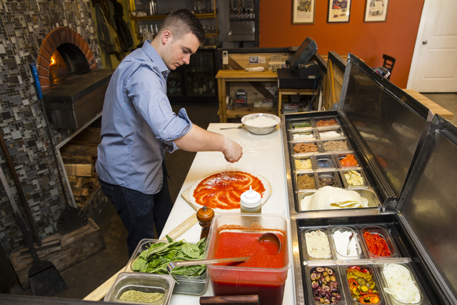 Jonathan Shearman prepares a red pie made with local sausage, Verano sheep, cheese and basil. The pork is from 8 Hands Farm in Cutchogue. (Credit: Randee Daddona)